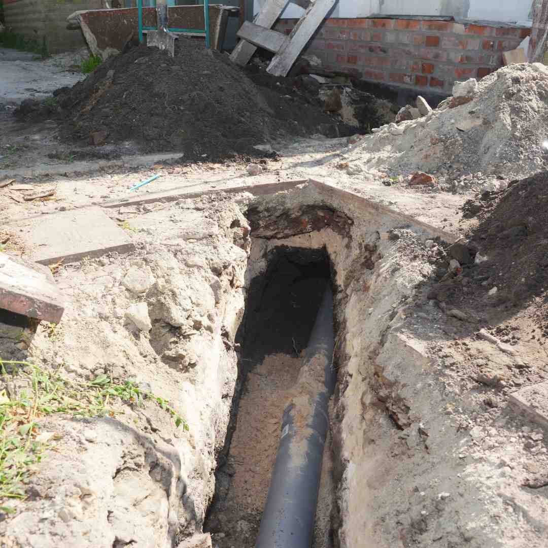 Digging a trench for a main drain pipe, sewer line to a sewer. Sewer line replacement or repair