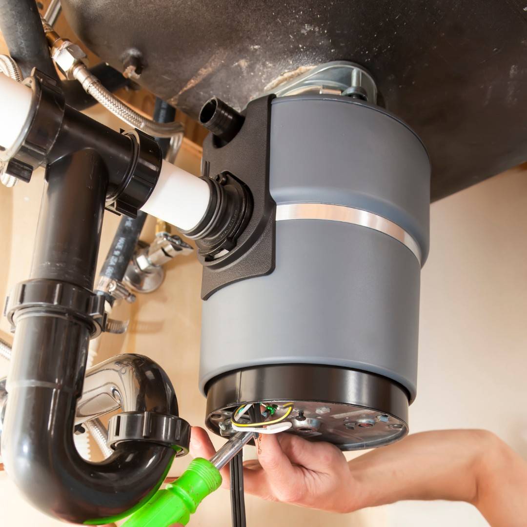 man installing garbage disposal in home