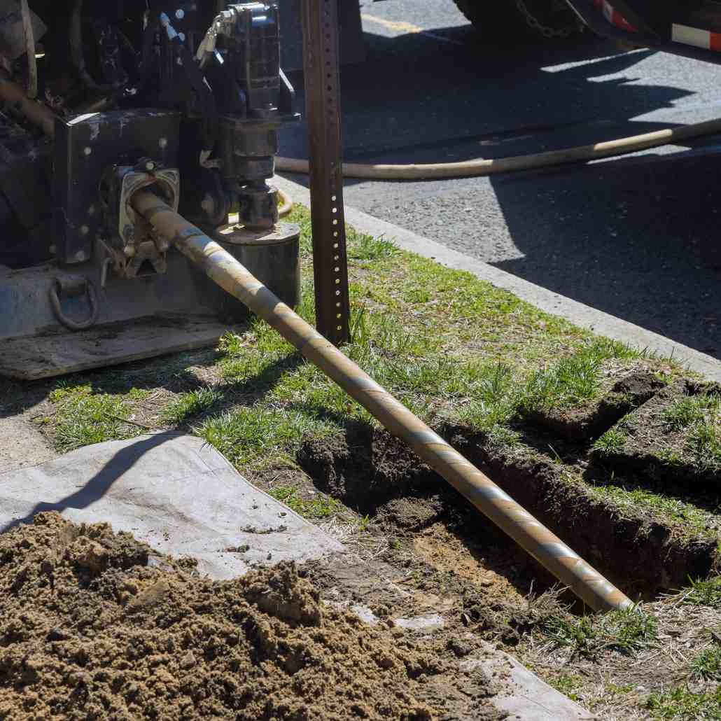 low angle view of trenchless laying of communications, fiber optic and water pipes with horizontal directional drilling technology machine work process