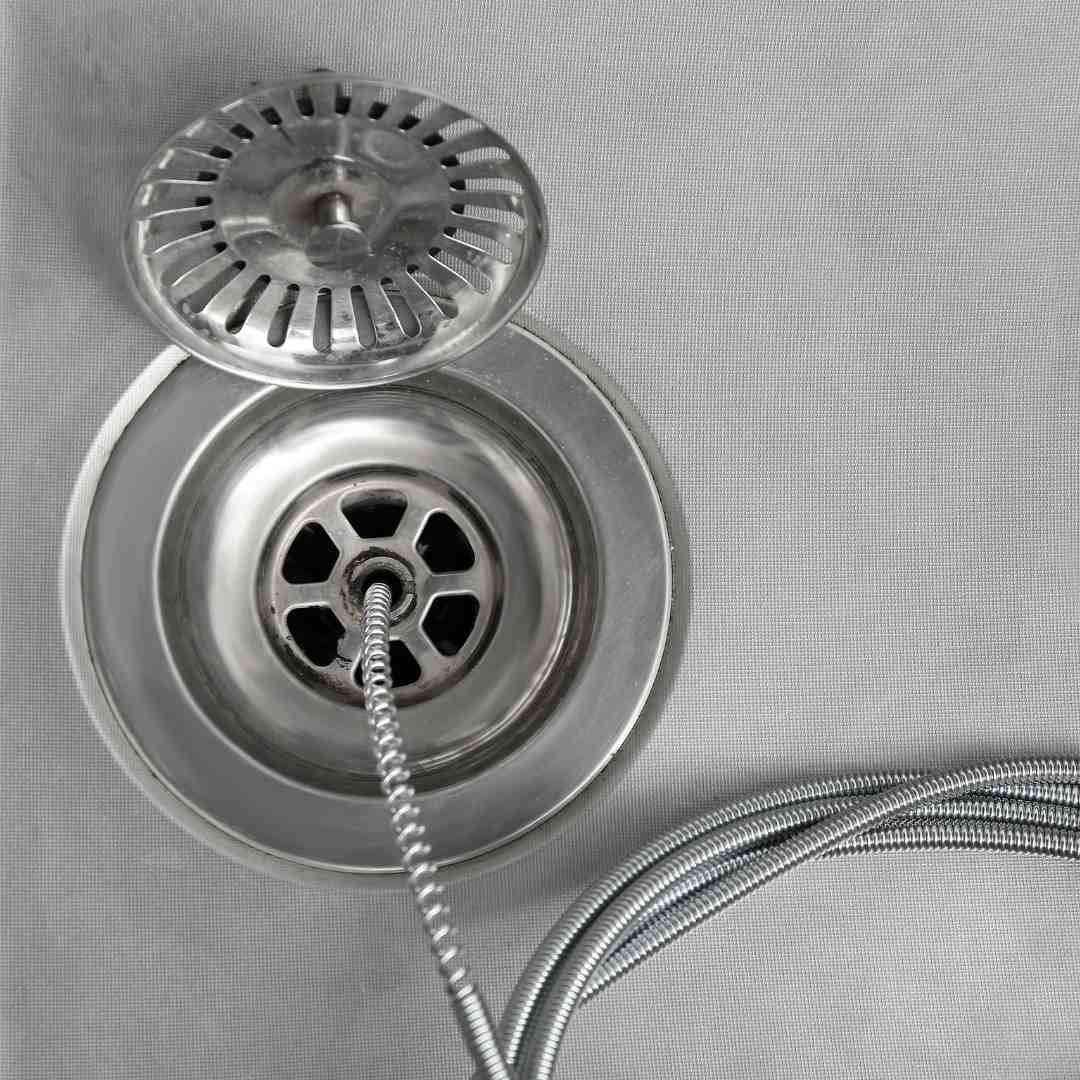 cleaning of drain with plumber's snake closeup