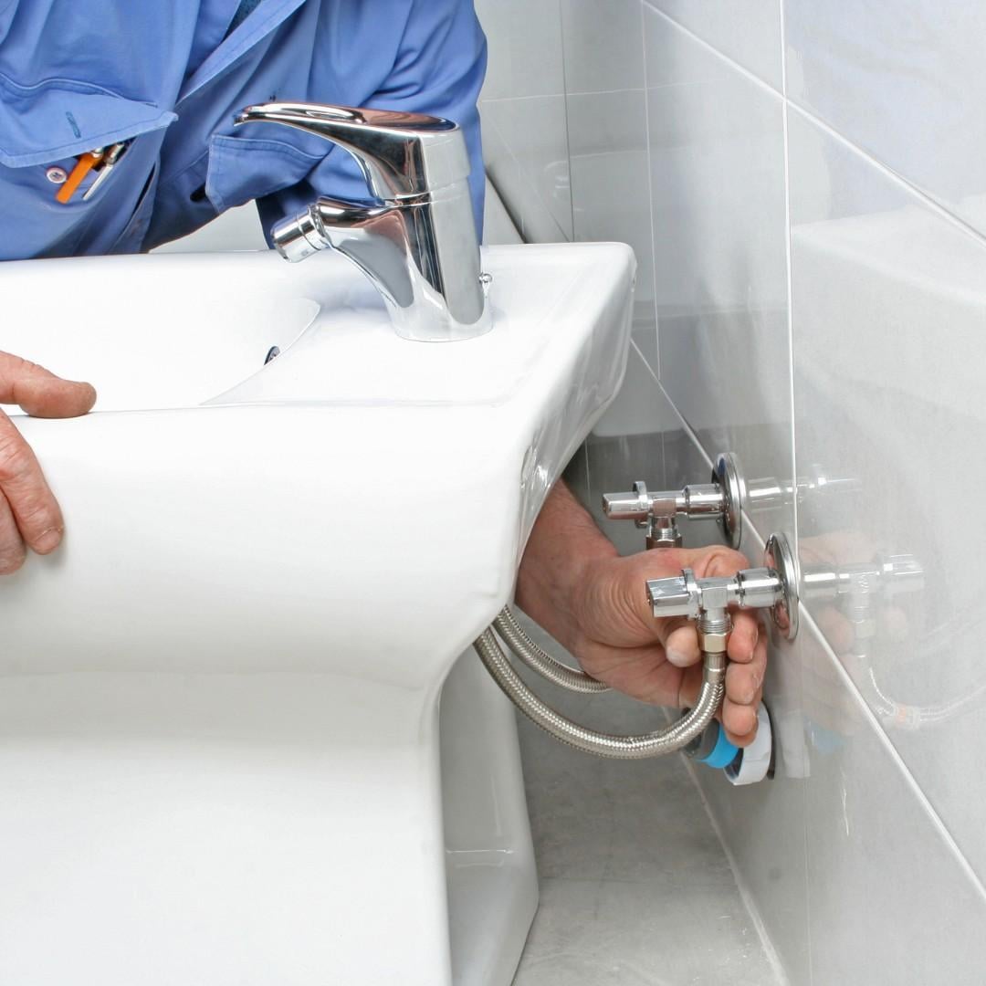 Construction worker installing a bidet in a bathroom